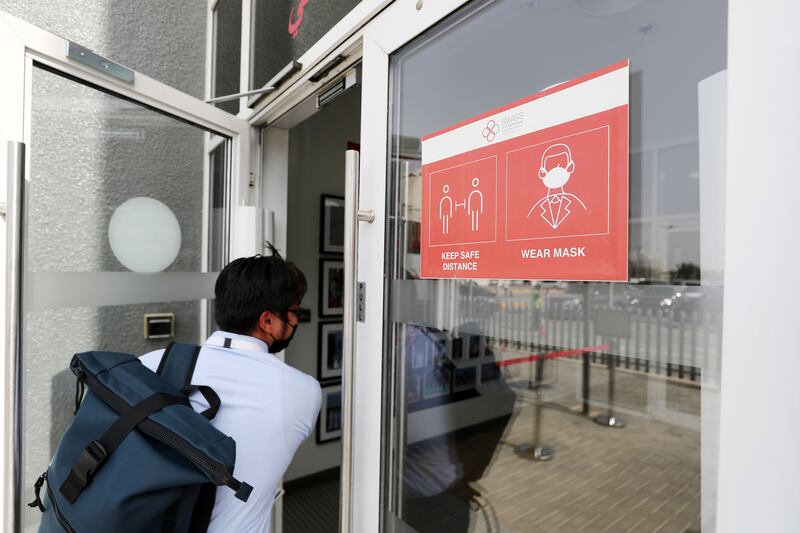 Signs remind people to wear a mask at the Swiss International Scientific School, Dubai. Chris Whiteoak / The National