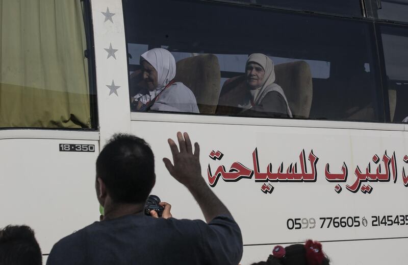 Palestinian wave to their pilgrim relatives at the Rafah border crossing between the Gaza Strip and Egypt.  AFP