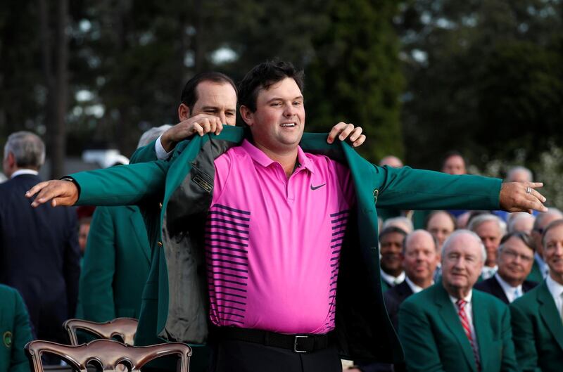 Sergio Garcia of Spain (rear), last year's Masters' champion, helps put the Green Jacket on 2018 Masters winner Patrick Reed following final round play of the 2018 Masters golf tournament at the Augusta National Golf Club in Augusta, Georgia, U.S. April 8, 2018. REUTERS/Jonathan Ernst     TPX IMAGES OF THE DAY