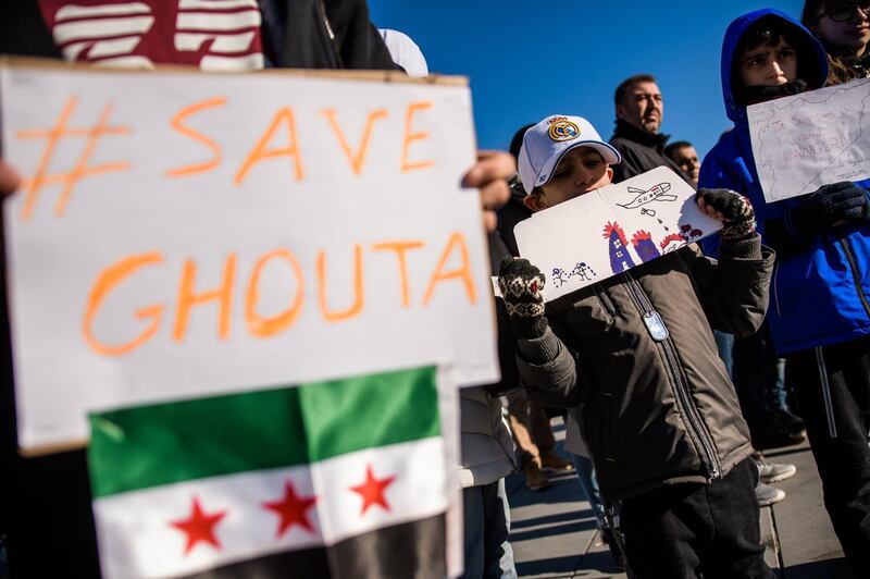 epa06564736 People carry posters which read 'save Ghouta' and  flags of the Syrian National Coalition during a protest to demand an immediate cease-fire in Eastern Ghouta, Syria, on the 'Place de la Republique' in Paris, France, 25 February 2018. The United Nations Security Council voted on 24 February 2018 for an immediate cease-fire in the area besieged by the Syrian army and its allies.  EPA/CHRISTOPHE PETIT TESSON