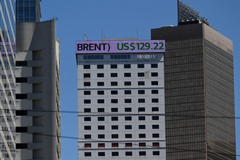 An electronic sign on a building shows the price of Brent crude oil in Hong Kong on March 9, 2022. A complete switch in energy trade from the dollar would only dent, not end, its dominance. AFP