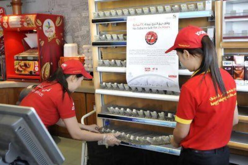 Staff of a Zoom store at a ENOC petrol station cleaned the cigarette display case as they were not selling tobacco products in their stores on World No Tobacco Day in Dubai. Charles Crowell for The National
