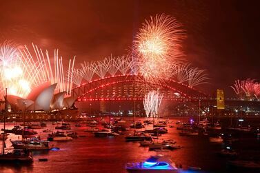 TOPSHOT - New Year's Eve fireworks erupt over Sydney's iconic Harbour Bridge and Opera House (L) during the fireworks show on January 1, 2020. / AFP / PETER PARKS