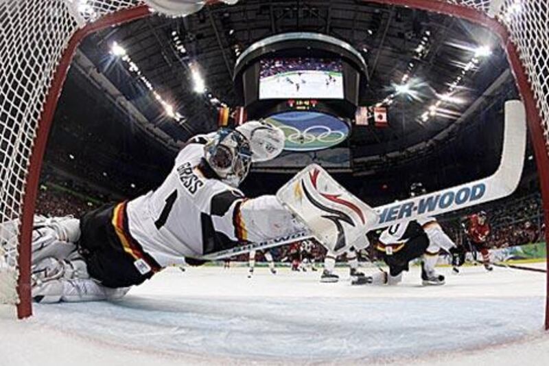 Thomas Greiss, the Germany goaltender, stretches to block a shot against Canada during their qualification game.