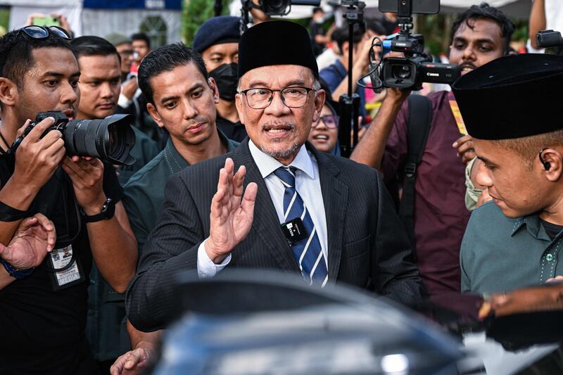 Malaysian opposition leader Anwar Ibrahim waves after meeting Malaysia's King, Sultan Abdullah, at the National Palace in Kuala Lumpur on Tuesday. AFP