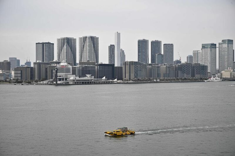 A boat sails through Tokyo bay cefore the city skyline on April 7, 2020. Japan's Prime Minister Shinzo Abe will on April 7 declare a state of emergency in parts of the country, including Tokyo, over a spike in coronavirus infections. / AFP / Philip FONG
