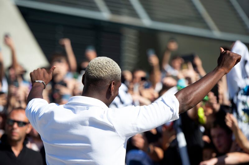 Midfielder Paul Pogba acknowledges fans as he arrives for his medical in Turin. AP