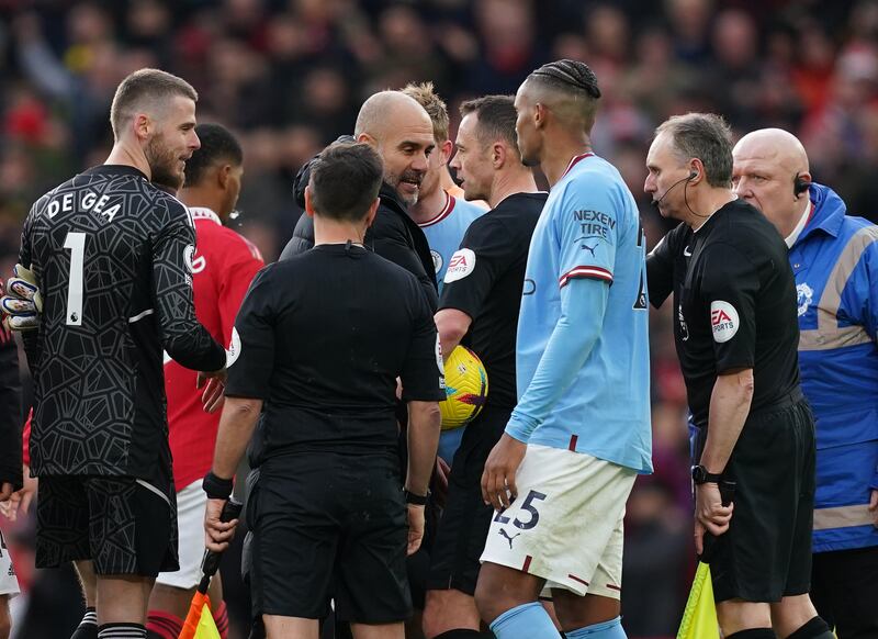 Pep Guardiola confronts referee Stuart Attwell and the assistant referee after Manchester City's defeat to Manchester United. PA