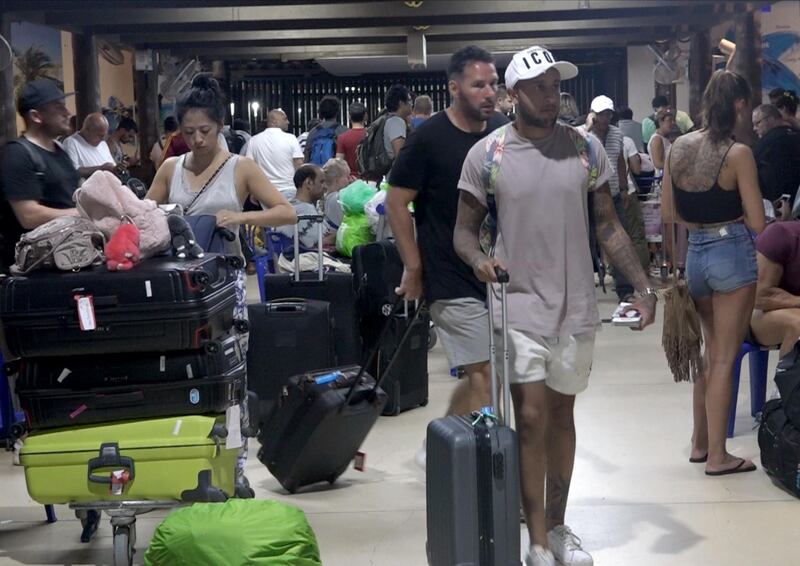 Foreign tourists with their belongings wait as their flights to leave the island of Samui have been cancelled following a tropical storm Pabuk weather warning, at an airport of Koh Samui Island, Surat Thani province, southern Thailand.  EPA