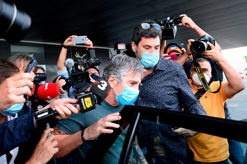 Jorge Messi fights his way through the crowd to a waiting car. AFP