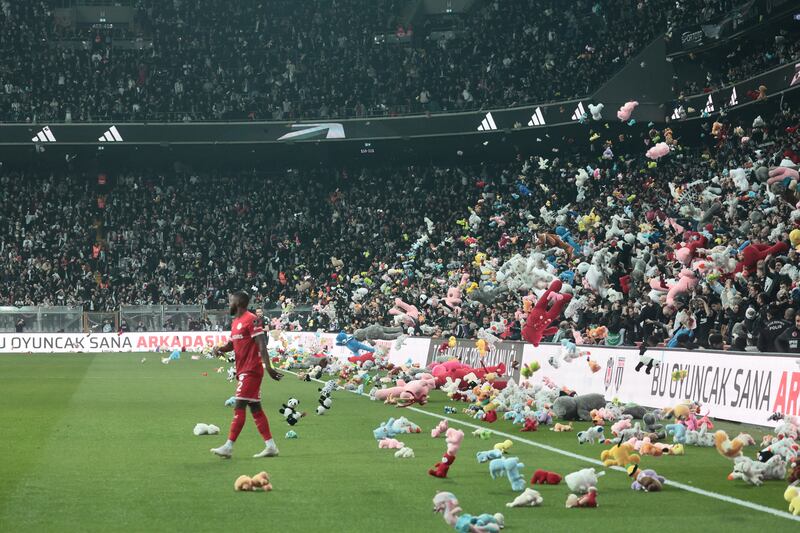 Fans throw toys on the pitch for children affected by earthquake during a Turkish Super League match between Besiktas and Antalyaspor. Reuters