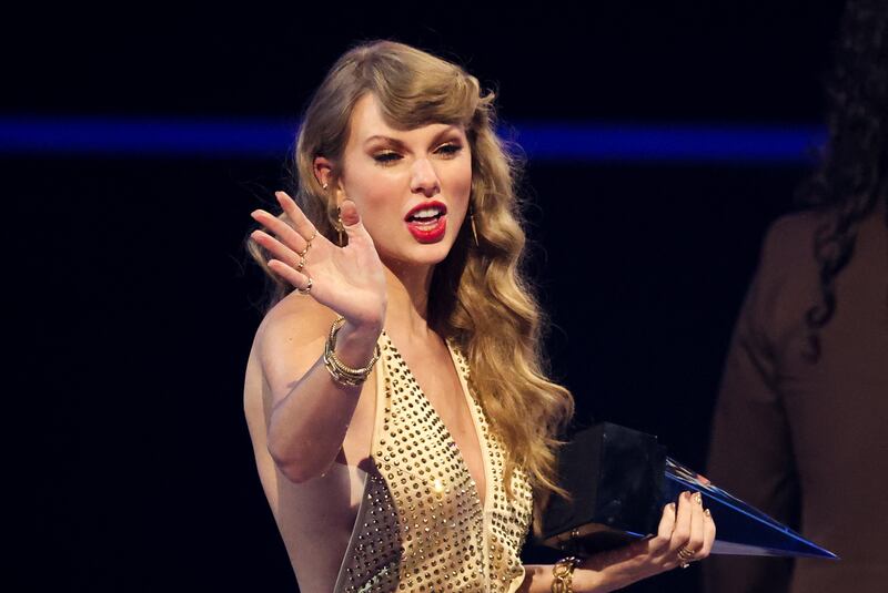 Swift waves after receiving the Artist of the Year award. Reuters