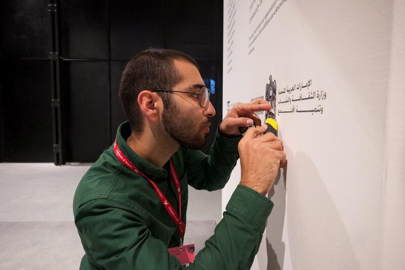 Bahar Al Bahar putting the finishing touches on the exhibition wall text ahead of the opening at the UAE's National Pavilion. (Courtesy: Bahar Al Bahar)