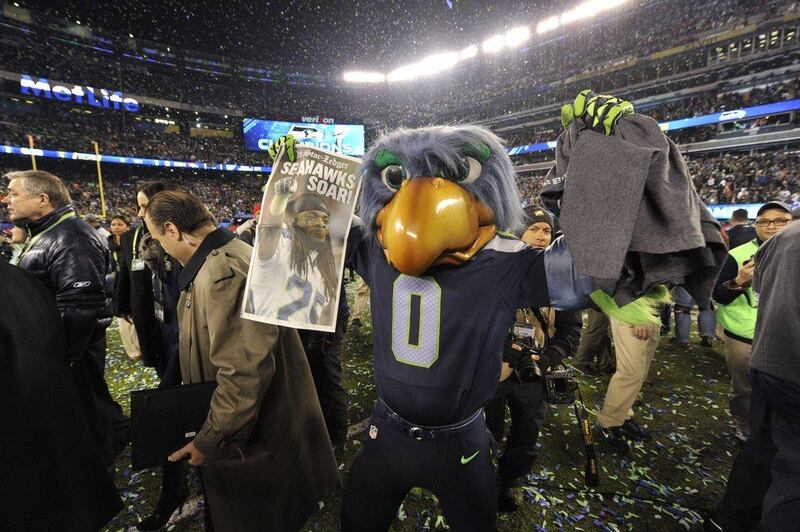 The Seattle Seahawks mascot, Taima the Hawk, holds up an early edition of the Monday newspaper after Seattle's victory in the Super Bowl on Sunday. Timothy Clary / AFP