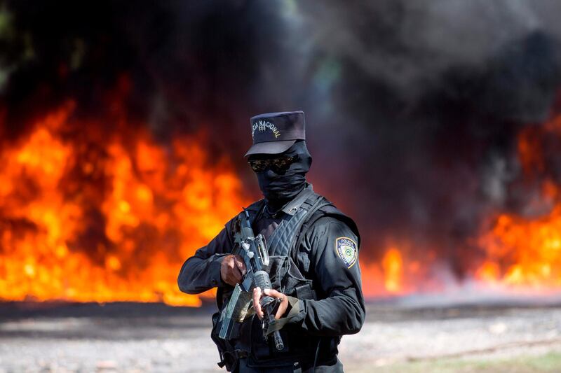 A policeman stands guard as more than 14 tonnes of cocaine and marijuana is incinerated at a military base in Pedro Brand, Santo Domingo province, Dominican Republic.   AFP