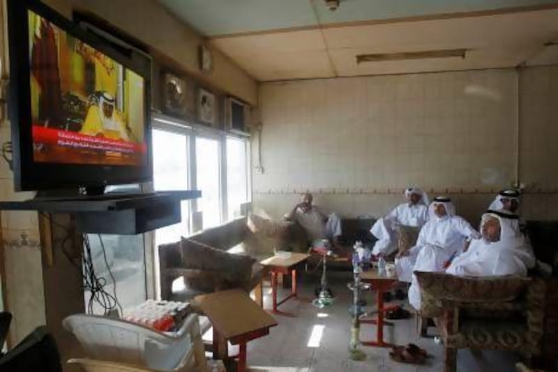 Qatari nationals watch their former emir, Sheikh Hamad bin Khalifa Al Thani, make his abdication speech from a cafe in Doha.