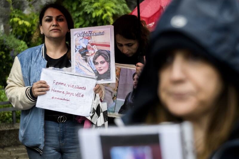 Protesters hold signs featuring images of Amini during the protest in the western Swiss city. EPA