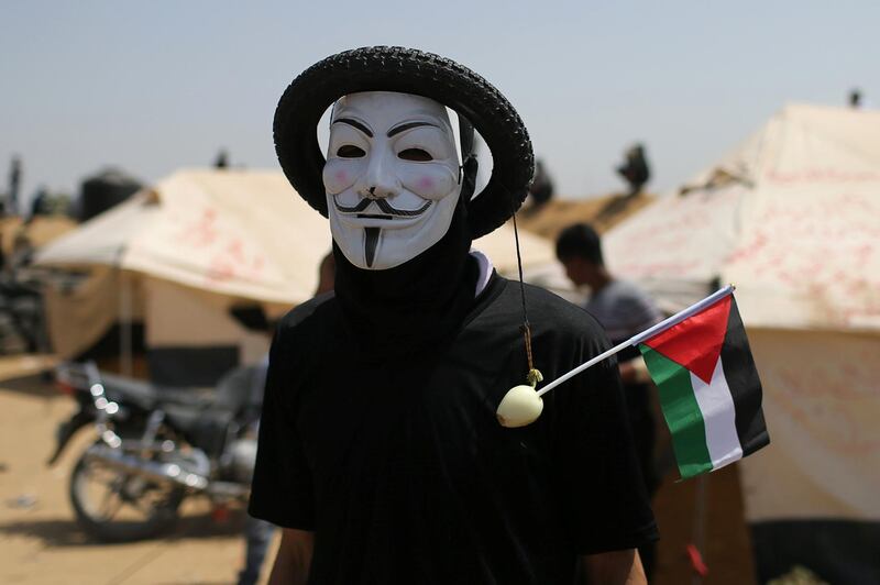 A Palestinian demonstrator wears a mask with a tire during a protest at the Israel-Gaza border in the southern Gaza Strip April 6, 2018. Picture taken April 6, 2018. REUTERS/Ibraheem Abu Mustafa