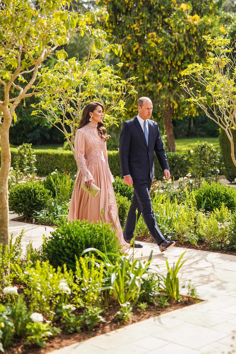 Britain's Prince William arrives with Catherine, Princess of Wales, who is wearing a blush-pink Elie Saab gown and carrying a gold clutch from Wilbur & Gussie