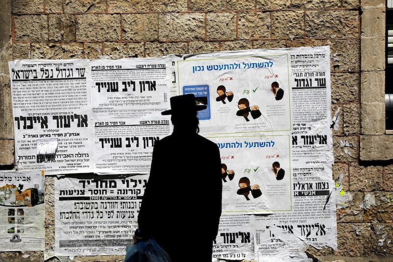 A Jewish ultraorthodox man looks onto a local billboard with instructions related to coronavirus in the Orthodox Jewish neighbourhood of Jerusalem on March 27, 2020. Reuters