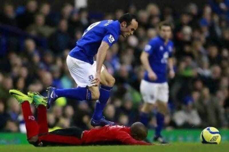 Everton's Landon Donovan, top, jumps over Tamworth's Danny Thomas during the third-round tie at Goodison Park yesterday.