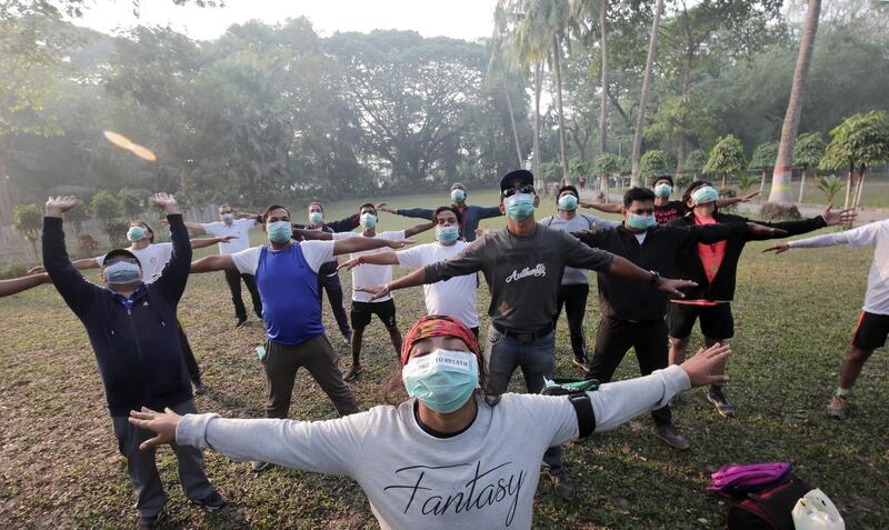 Indian activists and locals use medical protection mask as they do morning exercises in a park as part of an awareness campaign, in Kolkata, Eastern India. EPA