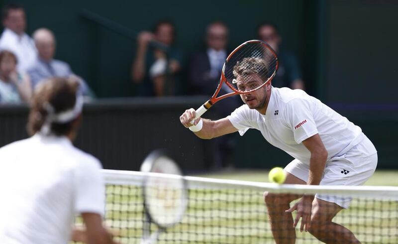 Stan Wawrinka returns to Roger Federer during their singles match on Wednesday at the 2014 Wimbledon Championships. Andrew Cowie / AFP