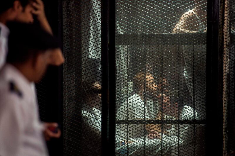 Detainees sit inside the soundproof glass dock of the courtroom during the trial of 700 defendants including Egyptian photojournalist Mahmoud Abu Zeid, widely known as Shawkan, in the capital Cairo. AFP