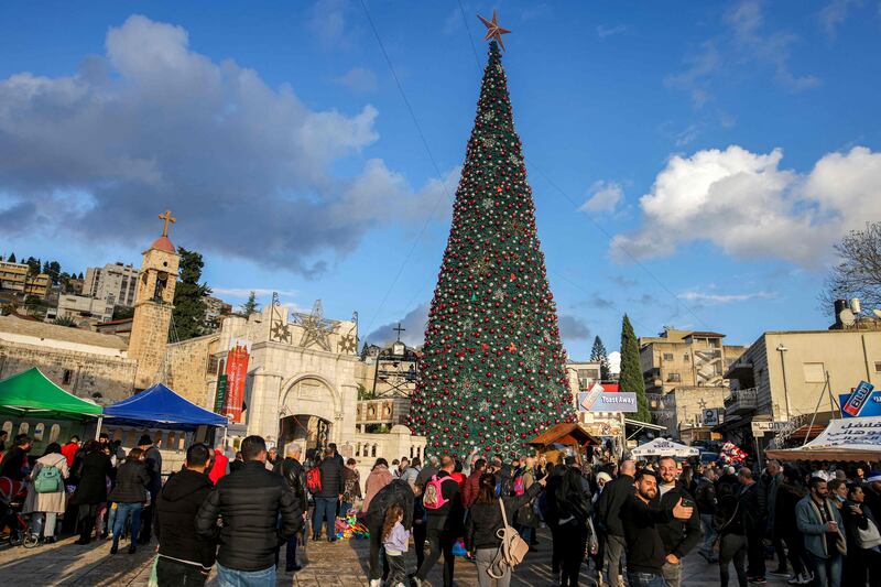 People gather around the giant Christmas tree outside the Greek Orthodox Church of the Annunciation in Israel's northern city of Nazareth.  AFP