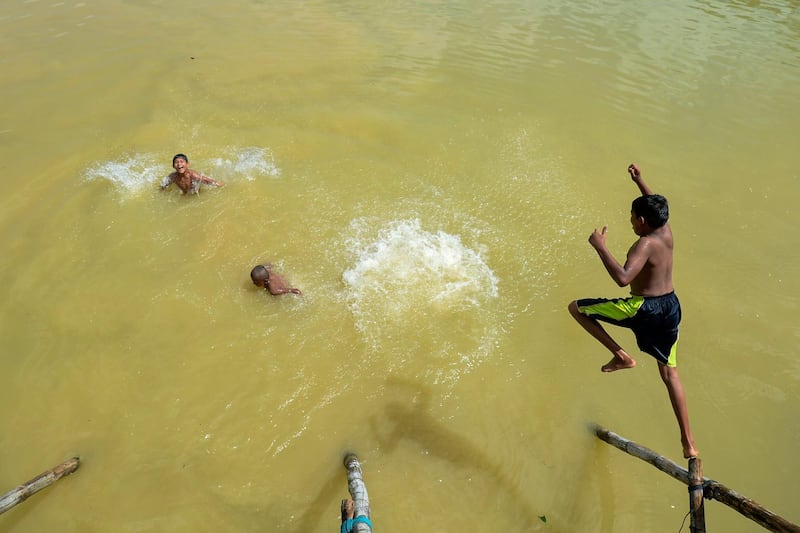 Rohingya refugee children cool off in a pond at Kutupalong refugee camp in Ukhia. AFP