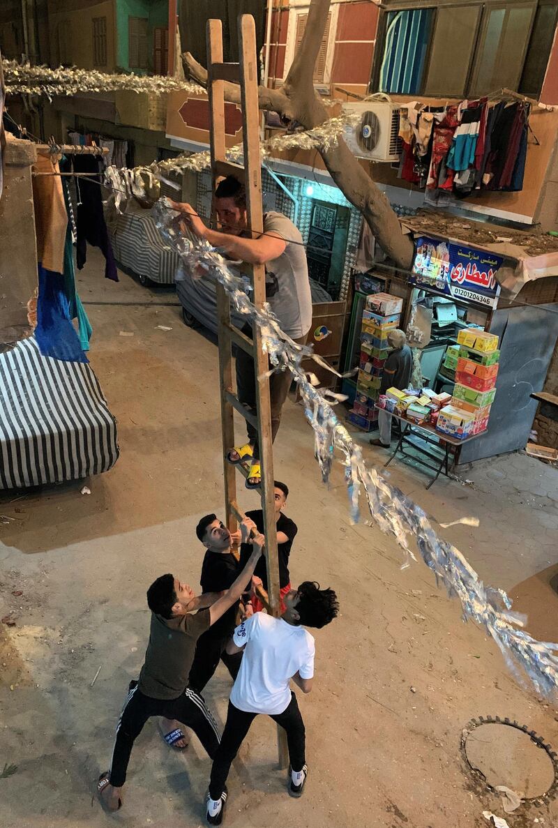 Egyptian youths prepare decorations for the Muslim holy month of Ramadan, also known to Egyptians as "Zeinat Ramadan" on a street in front of their homes during the night-time curfew to contain the spread of the coronavirus disease (COVID-19) in Cairo, Egypt,. REUTERS