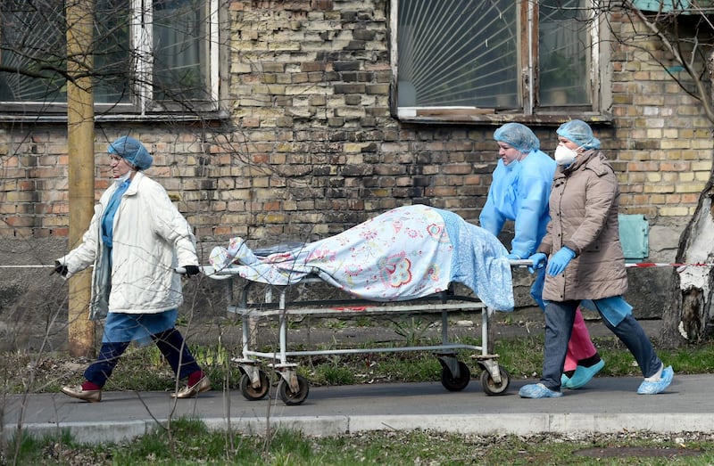 Medical workers carry a body on a stretcher from an hospital to the morgue in Kiev as Ukraine registered this week a record number of deaths and hospitalisations due to the Covid-19. Coronavirus unit is overwhelmed by patients who are admitted to the hospital round the clock as the country's aging healthcare system struggles to cope with the spread of the virus. AFP