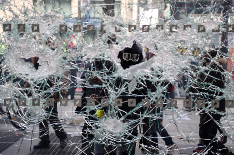 Yellow-vest protesters destroy a shop window during clashes with riot police on the Champs-Elysees in Paris on March 16, 2019. AFP