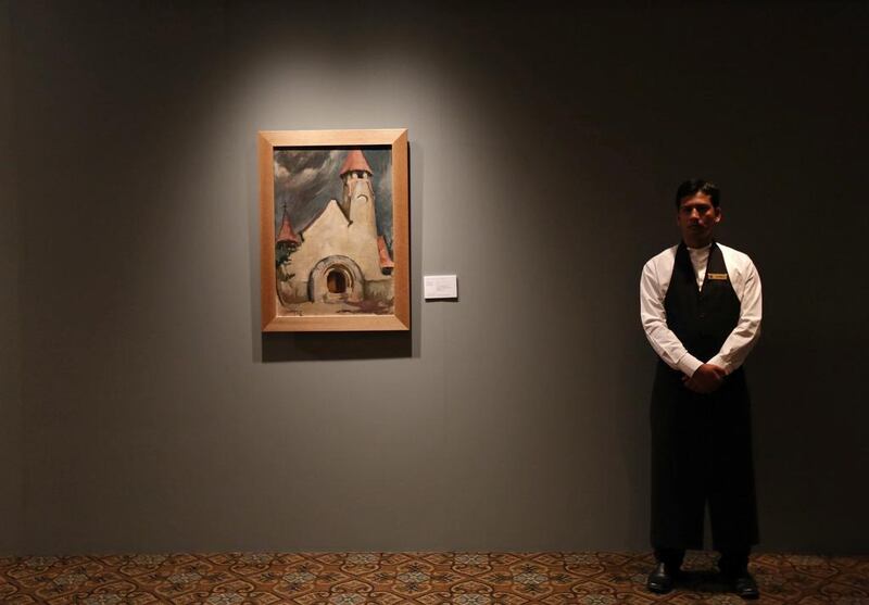 An employee of the Taj Mahal Palace hotel in Mumbai stands inside a gallery before the start of Christie's first auction in India. Mansi Thapliyal / Reuters