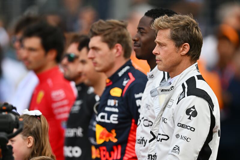 Pitt and Idris observe the national anthem on the Silverstone grid. Getty