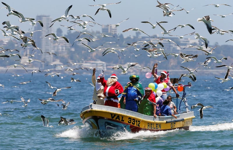 A man dressed in a Santa Claus outfit waves to people from a fisherman's boat on Christmas Eve along the coast of Valparaiso, Chile, on December 24, 2017. Rodrigo Garrido / Reuters