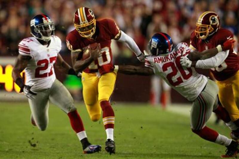 Washington Redskins quarterback Robert Griffin III evades a tackle from the Giants' Prince Amukamara.