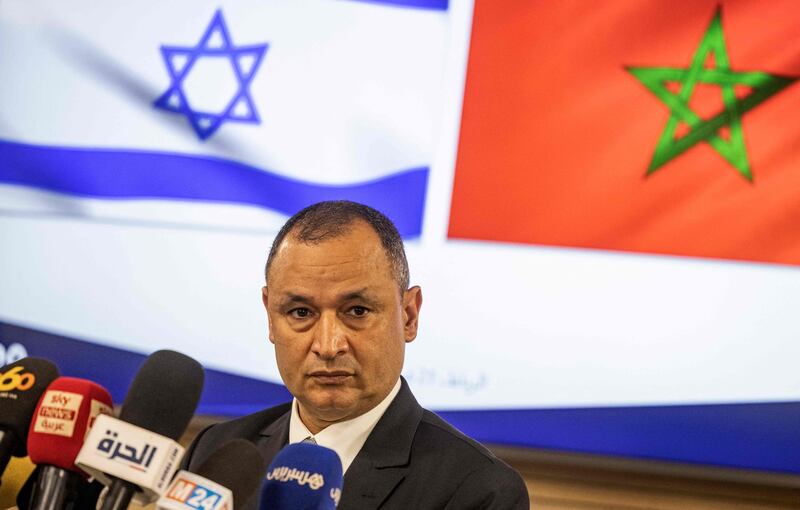 Ryad Mezzour addresses the media under the flags of Israel and Morocco. AFP