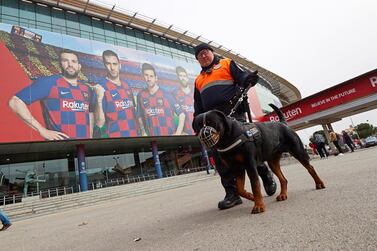 A security guard and his dog in front of Camp Nou, venue for the first clasico of the season between Barcelona and Real Madrid on Wednesday. There are concerns protesters backing Catalan independence will try to disrupt the match. EPA
