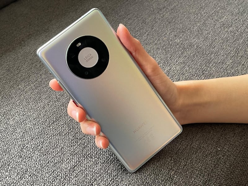 22 October 2020, Berlin: A woman holds a Mate 40 Pro smartphone from Huawei in her hand. The device has a distinctive Leica circular camera system with three objects and a laser sensor for distance measurement. Photo: Christoph Dernbach/dpa (Photo by Christoph Dernbach/picture alliance via Getty Images)