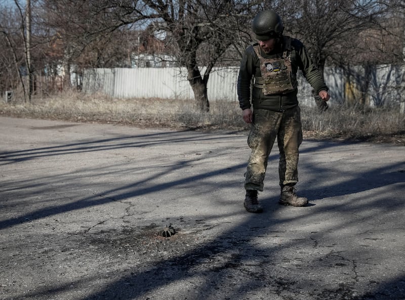 A Ukrainian soldier walks past fragments of a mortar shell amid fighting near the front line in Travneve, Donetsk region. Reuters