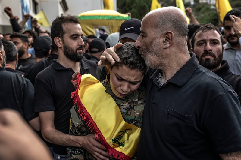 A man comforts the son of a Hezbollah militant killed during clashes against Israeli forces in the southern border of Lebanon. Getty Images