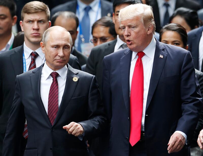 FILE - This Saturday, Nov. 11, 2017 file photo, shows U.S. President Donald Trump and Russia's President Vladimir Putin talking during the family photo session at the APEC Summit in Danang, Vietnam. When Trump meets Putin on Monday, July 16, 2018, the Syrian conflict will be the most immediately pressing issue on a wide-ranging agenda. (Jorge Silva/Pool Photo via AP, File)