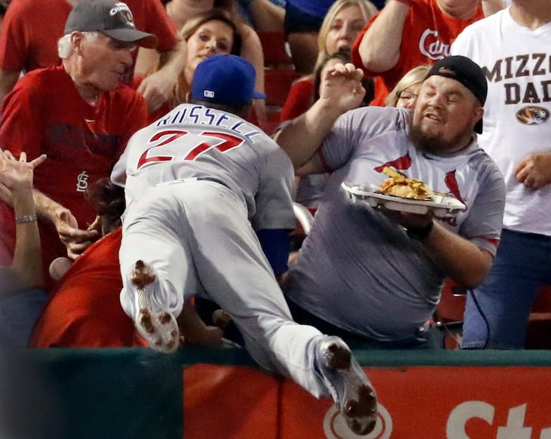 Chicago Cubs shortstop Addison Russell dives into the crowd but is unable to catch a foul ball hit by St. Louis Cardinals' Jedd Gyorko during the second inning of a baseball game. Jeff Roberson / AP Photo