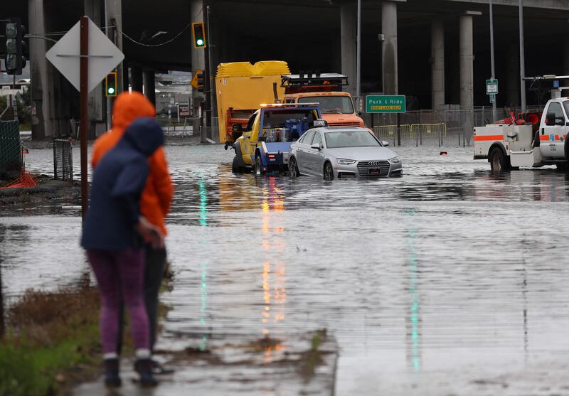 A tow truck pulls a car from a flooded junction in Mill Valley, California, on Wednesday. Getty