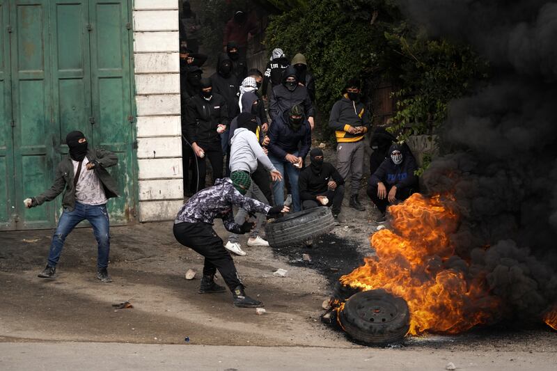 Tyres burn as violence flares between Palestinian protesters and Israeli troops in the occupied West Bank following the funeral of Mufid Khalil in the village of Beit Ummar, near Hebron. AP