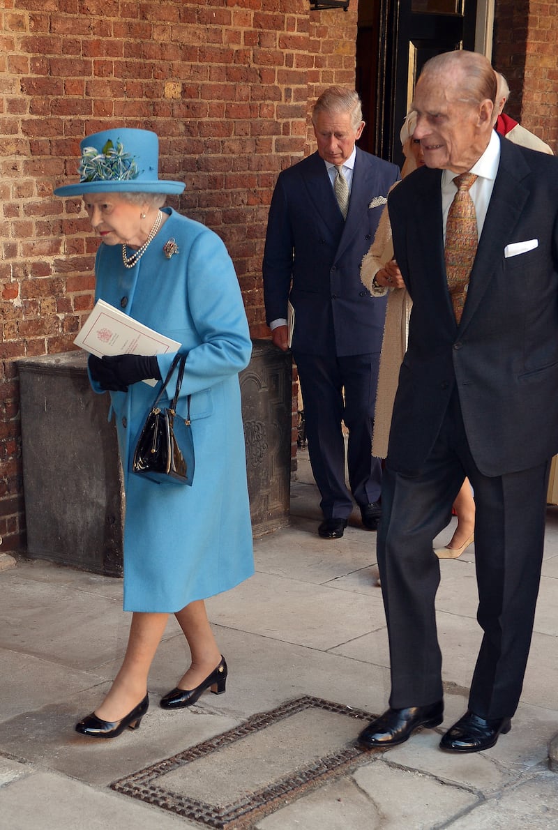 Queen Elizabeth II, wearing blue, and Prince Philip, Duke of Edinburgh, after the christening of Prince George at St James's Palace on October 23, 2013, in London. Getty Images