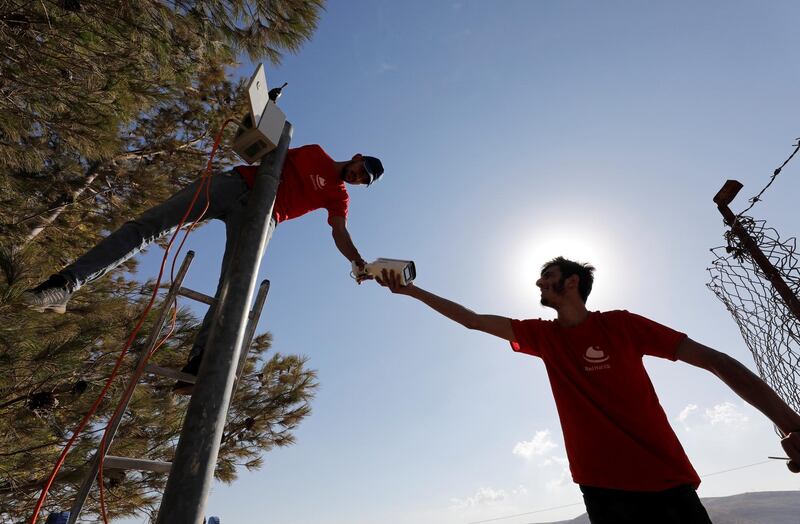 Workers install a video surveillance system to keep an eye on nearby Israeli settlers who Palestinians accuse of frequent attacks, in the village of Kisan in the West Bank. Reuters