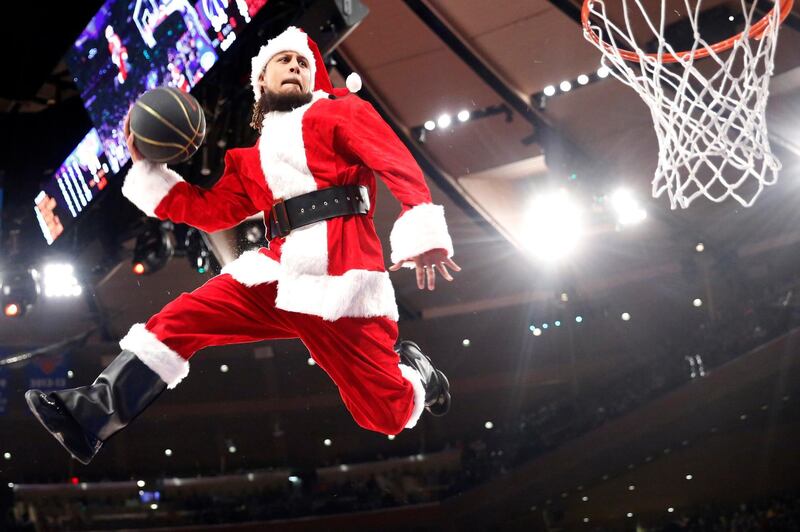 A "dunking Santa" uses a trampoline to get airborne during a timeout in the NBA game between the New York Knicks and Washington Wizards on Monday, Deccember 23, 2019. The Wizards won 121-115. AP