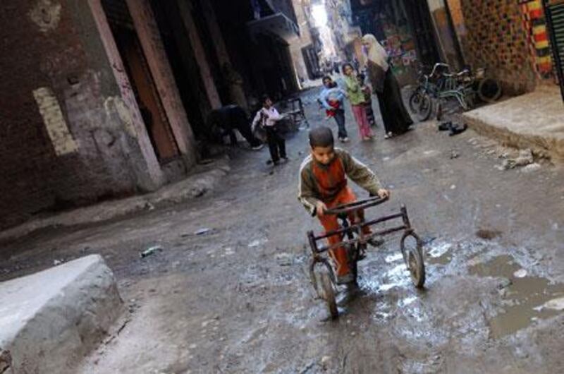 A boy rides a bicycle through the streets of the Bashteel district of Imbaba.